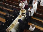 Rev. John P. Harrington blesses the casket during the funeral ceremony for Detective Luis Alvarez, at Immaculate Conception Church, in the Queens borough of New York, Wednesday, July 3, 2019. Alvarez, 53, who died after a three-year battle with colorectal cancer, fought until his final days for the extension of the Sept. 11 Victim Compensation Fund.