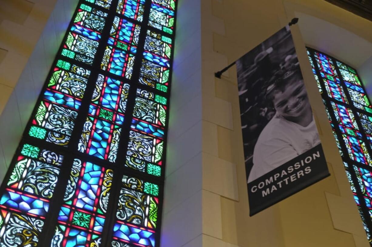 FILE - In this Feb. 12, 2019 file photo, a banner hangs by a stained glass window in the sanctuary at Glide Memorial United Methodist Church in San Francisco. Most Americans don’t typically reach out to religious leaders for guidance, according to a poll from The Associated Press-NORC Center for Public Affairs Research. The poll shows the lack of personal connection with ministers even includes people who identify with a religion, though it’s less prevalent among those most engaged with their faith.