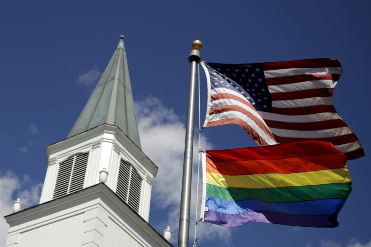 FILE - In this April 19, 2019 file photo, a gay pride rainbow flag flies along with the U.S. flag in front of the Asbury United Methodist Church in Prairie Village, Kan.