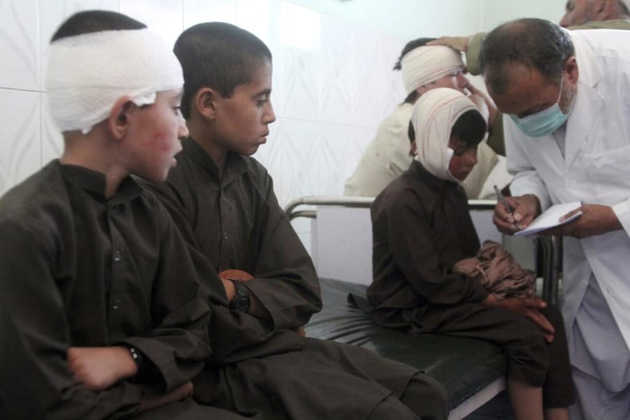 Injured boys receive treatment in a hospital after a car bomb attack in Ghazni province, central Afghanistan, Sunday, July 7, 2019. Afghan officials say a car bomb in central Afghanistan has killed a few people and wounded dozens of people, many of them students attending a nearby school.