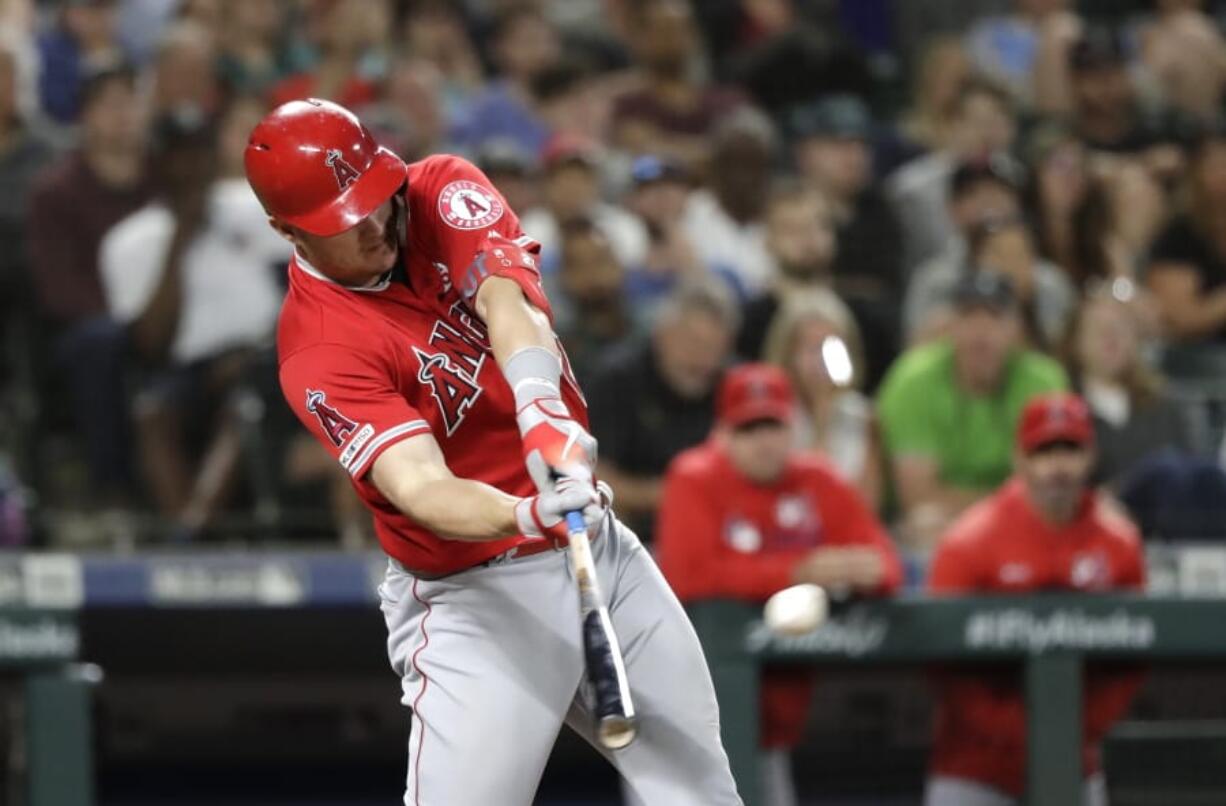 Los Angeles Angels’ Mike Trout connects on a three-run home run against the Seattle Mariners in the ninth inning Saturday in Seattle.