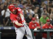 Los Angeles Angels’ Mike Trout connects on a three-run home run against the Seattle Mariners in the ninth inning Saturday in Seattle.