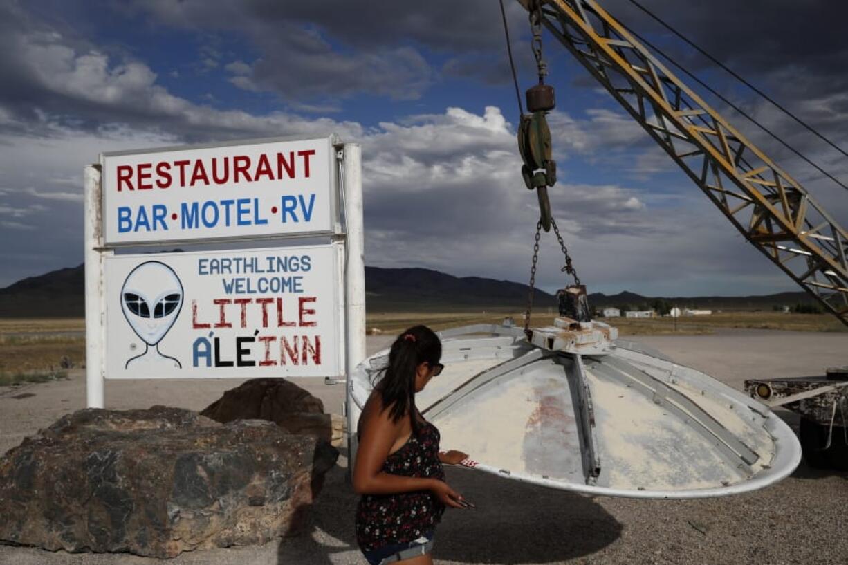 In this July 22, 2019 photo, Grace Capati looks at a UFO display outside of the Little A’Le’Inn, in Rachel, Nev., the closest town to Area 51. The U.S. Air Force has warned people against participating in an internet joke suggesting a large crowd of people “storm Area 51,” the top-secret Cold War test site in the Nevada desert.