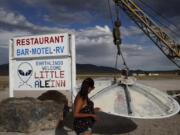 In this July 22, 2019 photo, Grace Capati looks at a UFO display outside of the Little A’Le’Inn, in Rachel, Nev., the closest town to Area 51. The U.S. Air Force has warned people against participating in an internet joke suggesting a large crowd of people “storm Area 51,” the top-secret Cold War test site in the Nevada desert.