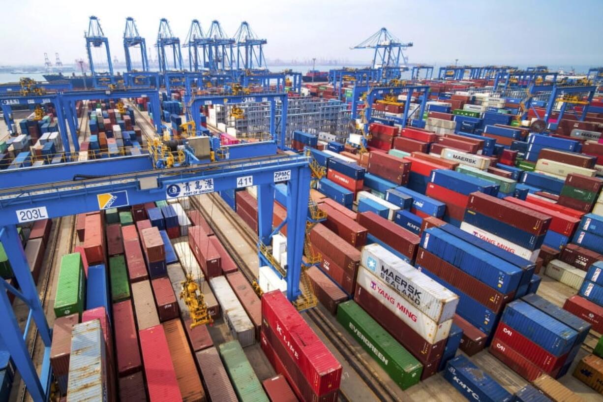 In this Tuesday, May 14, 2019, photo, containers are piled up at a port in Qingdao in east China’s Shandong province. China’s imports from the United States plunged 31.4% in June from a year earlier amid a tariff war with Washington, while exports to the U.S. market sank 7.8%, Customs data showed Friday, July 12, 2019.