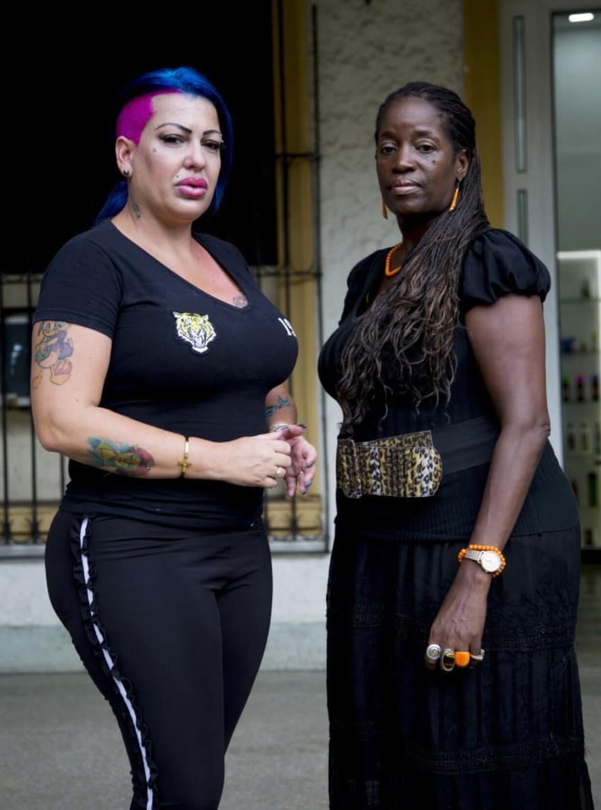 In this June 28, 2019, photo, Dianelys Alfonso, left, singer stands with her lawyer Deyni Terry, for a photo during an interview with The Associated Press in Havana, Cuba. Alfonso publicly denounced another renowned musician, flutist and bandleader José Luis Cortés, accusing him of repeatedly hitting and raping her during her time as vocalist for NG La Banda. Terry said she and her client are investigating whether they can bring charges of abuse and sexual assault against Cortés many years after the alleged crimes took place.