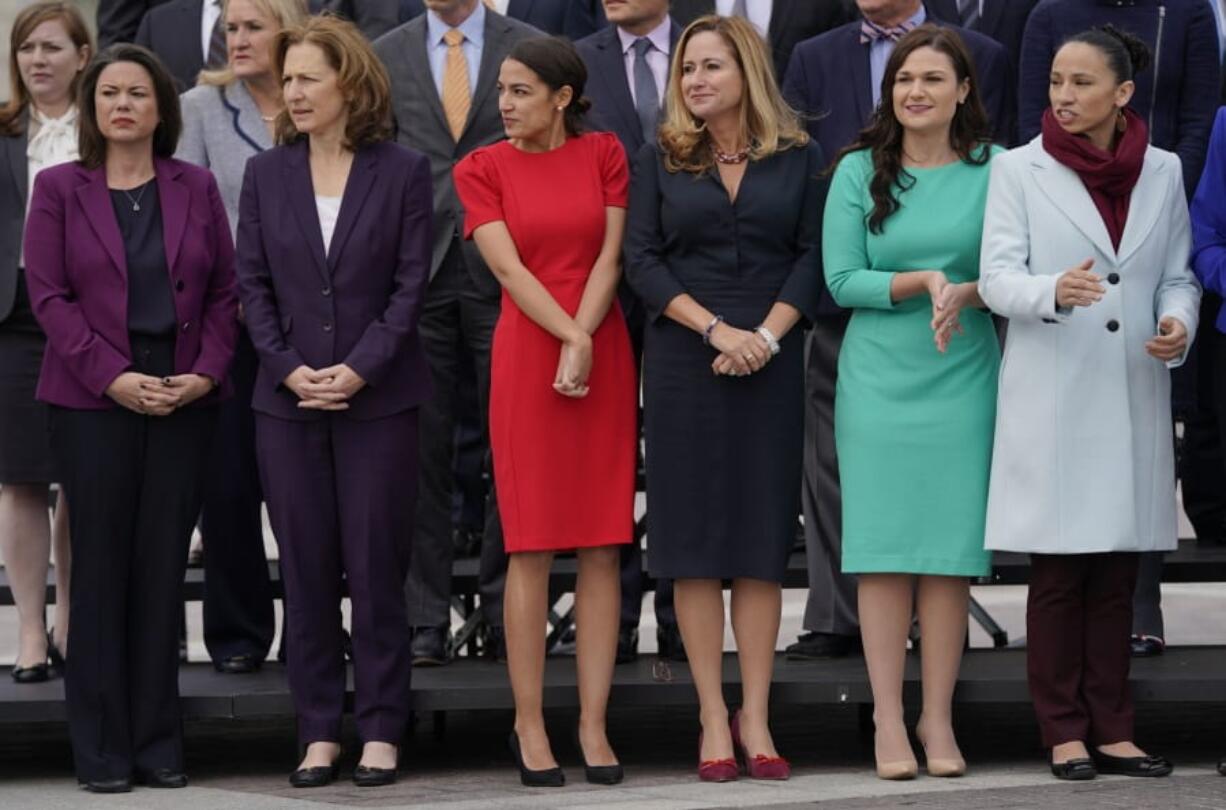 FILE - In this Nov. 14, 2018 file photo, from l-r., Rep.-elect Angie Craig, D-Minn., Rep.-elect Kim Schrier, D-WA., Rep.-elect Alexandria Ocasio-Cortez, D-NY., Rep.-elect Debbie Mucarsel-Powell, D-Fla., Rep.-elect Abby Finkenauer, D-Iowa, and Rep.-elect Sharice Davids, D-KS., line up as they join other members of the freshman class of Congress for a group photo on Capitol Hill in Washington.