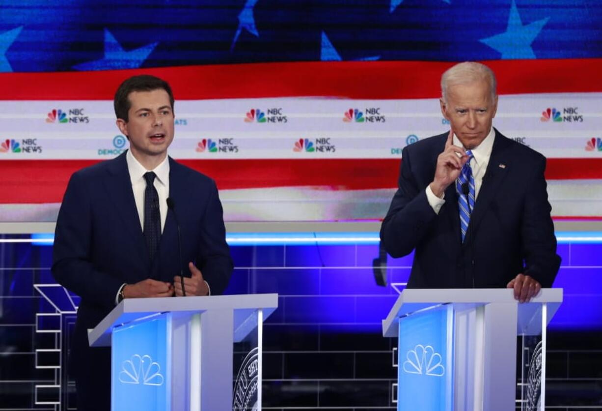 FILE - In this June 27, 2019, file photo, Democratic presidential candidate South Bend Mayor Pete Buttigieg, left, speaks as former vice president Joe Biden gestures during the Democratic primary debate hosted by NBC News at the Adrienne Arsht Center for the Performing Art in Miami. Biden and Buttigieg represent the generational poles of the crowded Democratic presidential primary. Biden is hoping Democratic voters see his decades of experience as the remedy for Trump’s presidency. Buttigieg argues that the moment calls for the energy of a new generation.