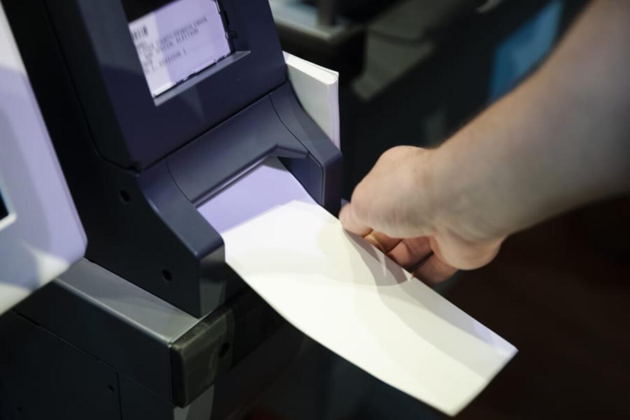 In this June 13, 2019, photo, Steve Marcinkus, an Investigator with the Office of the City Commissioners, demonstrates the ExpressVote XL voting machine at the Reading Terminal Market in Philadelphia. An analysis by The Associated Press has found that the vast majority of the nation’s 10,000 election jurisdictions will be managing their elections on Windows 7 or an even older operating system.