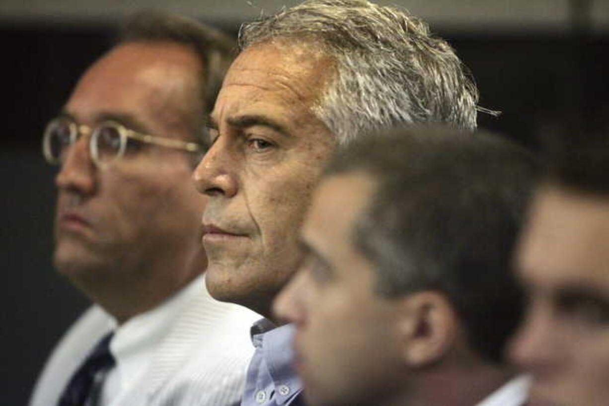 In this July 30, 2008 file photo, Jeffrey Epstein, center, is shown in custody in West Palm Beach, Fla. The wealthy financier and convicted sex offender has been arrested in New York on sex trafficking charges. Two law enforcement officials said Epstein was taken into federal custody Saturday, July 6, 2019, on charges involving sex-trafficking allegations that date to the 2000s.