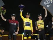 Colombia’s Egan Bernal, the winner, center, Britain’s Geraint Thomas, who placed second, left, and the Netherlands’ Steven Kruijswijk, third, stand on the podium of the Tour de France cycling race in Paris, France, Sunday, July 28, 2019.