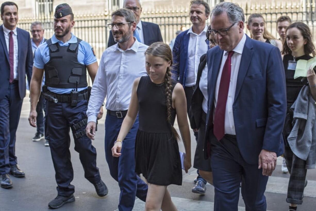 Swedish climate activist Greta Thunberg, centre, arrives for a meeting Tuesday at the French National Assembly in Paris, France.