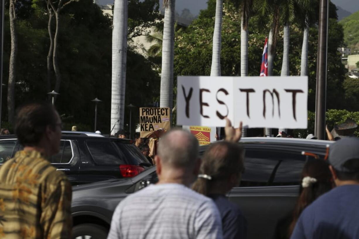 Supporters of the Thirty Meter Telescope, foreground, gather for a rally outside the Hawaii State Capitol in Honolulu on Thursday, July 25, 2019, as opponents of the telescope gather across the street. Supporters said the giant telescope planned for Hawaii’s tallest mountain will enhance humanity’s knowledge of the universe and bring quality, high-paying jobs, as protesters blocked construction for a second week.