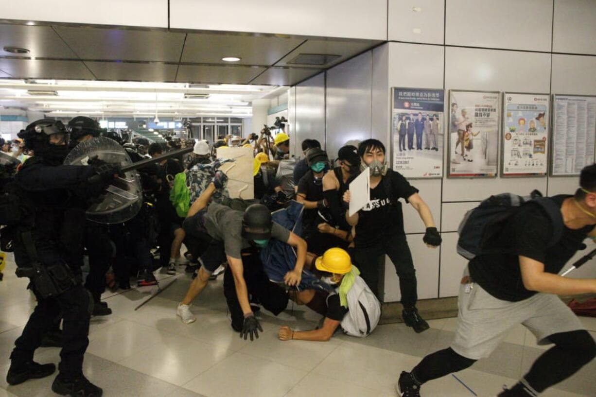 Special Tactical Squad officers attack protesters with batons who refused to disperse from a train station in Yuen Long district in Hong Kong on Saturday, July 27, 2019.