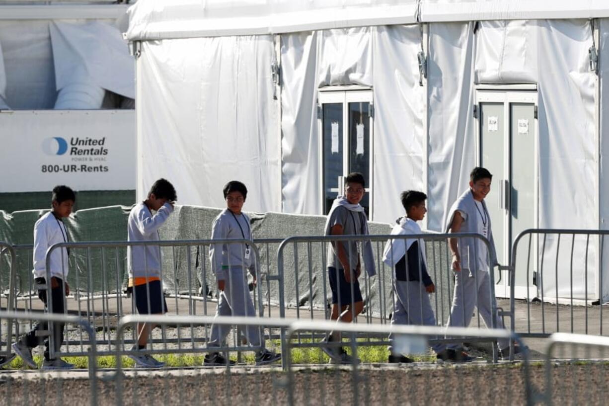 FILE - In this Feb.19, 2019 file photo, children line up to enter a tent at the Homestead Temporary Shelter for Unaccompanied Children in Homestead, Fla. A government spokesman says President Donald Trump’s administration is evaluating vacant properties near five U.S. cities as potential permanent sites to hold unaccompanied migrant children. Department of Health and Human Services spokesman Mark Weber said Wednesday that property is being assessed in and around Atlanta; Phoenix; Dallas; Houston; and San Antonio, Texas.