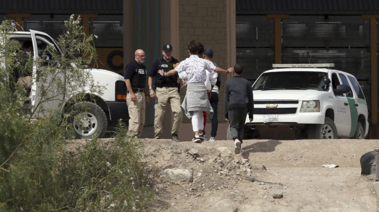 FILE - In this July 4, 2019 file photo, a group of asylum seekers cross the border between El Paso, Texas, and Juarez, Chihuahua, Mexico, Thursday, July 4, 2019.