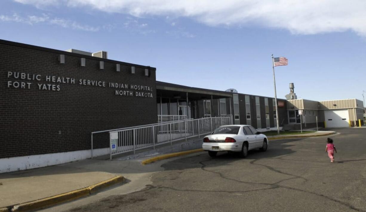 FILE - In this Oct. 14, 2008, a small child walks toward the front door of the Public Health Service Indian Hospital on the Standing Rock Reservation in Fort Yates. N.D. A federal audit released Monday, July 22, 2019, finds that government hospitals placed Native Americans at increased risk for opioid abuse and overdoses. The audit says a handful of Indian Health Service hospitals, including the Fort Yates Hospital, failed to follow the agency’s protocols for dispensing and prescribing the drug. The Indian Health Service agreed with the more than a dozen recommendations and says changes are in the works.