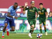 Portland Timbers midfielder Sebastian Blanco (10) battles for the ball with New York City defender Sebastien Ibeagha, left, during the second half of an MLS soccer match Sunday, July 7, 2019, in New York.