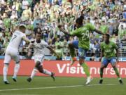 Portland Timbers forward Brian Fernandez, left, kicks a goal as forward Jeremy Ebobisse, second from left, as Seattle Sounders’ defenders Roman Torres (29) and Kelvin Leerdam, right, look on during the first half of an MLS soccer match, Sunday, July 21, 2019, in Seattle. (AP Photo/Ted S.