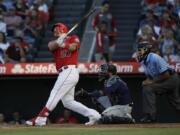 Los Angeles Angels' Mike Trout follows through on a two-run home run against the Seattle Mariners during the third inning of a baseball game Saturday, July 13, 2019, in Anaheim, Calif.