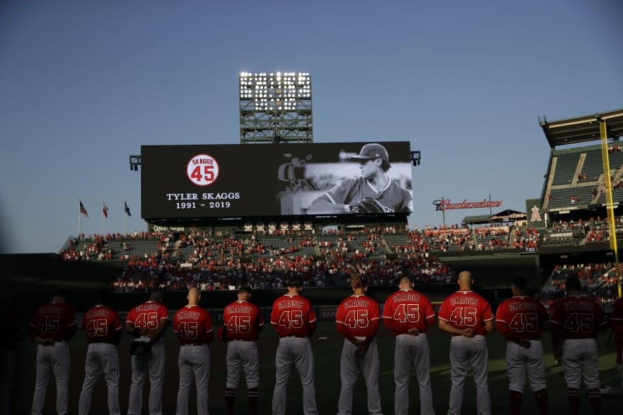 Members of the Los Angeles Angels observe a moment of silence for teammate Tyler Skaggs, before a baseball game against the Seattle Mariners on Friday, July 12, 2019, in Anaheim, Calif.