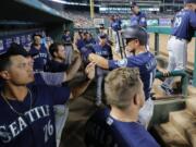 Seattle Mariners’ Kyle Seager, right, is congratulated in the dugout after scoring on a Tom Murphy single during the seventh inning of the team’s baseball game against the Texas Rangers in Arlington, Texas, Tuesday, July 30, 2019.