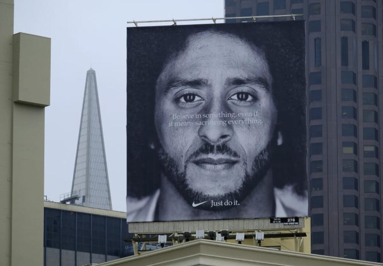 FILE - In this Sept. 5, 2018, file photo, a large billboard stands on top of a Nike store showing former San Francisco 49ers quarterback Colin Kaepernick, at Union Square in San Francisco. Nike is pulling a flag-themed tennis shoe after Kaepernick complained to the shoemaker, according to the Wall Street Journal.