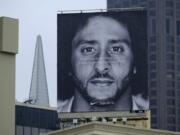 FILE - In this Sept. 5, 2018, file photo, a large billboard stands on top of a Nike store showing former San Francisco 49ers quarterback Colin Kaepernick, at Union Square in San Francisco. Nike is pulling a flag-themed tennis shoe after Kaepernick complained to the shoemaker, according to the Wall Street Journal.