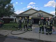 Vancouver firefighters survey the scene of a house fire Thursday afternoon in the North Image neighborhood.