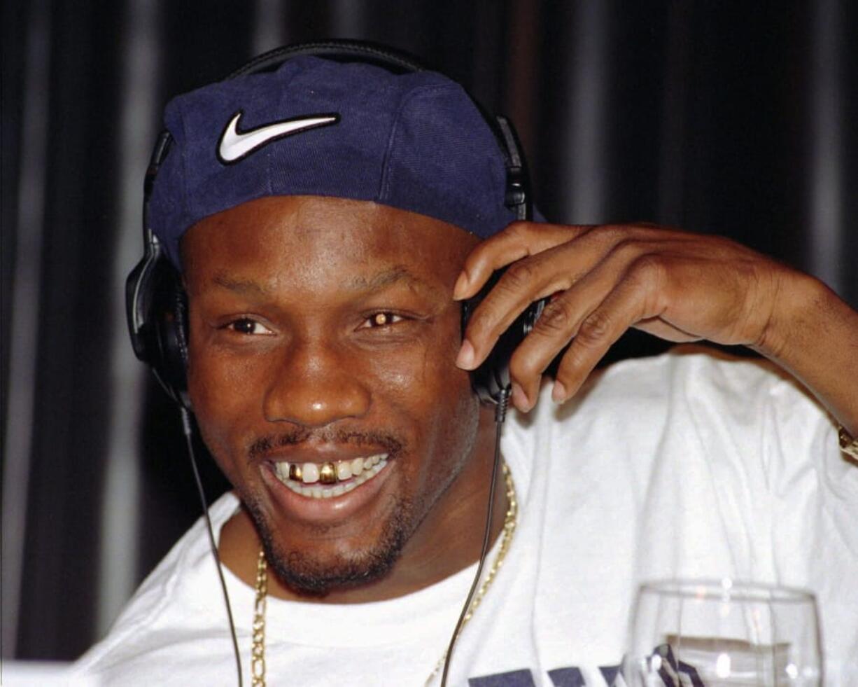 FILE - In this April 9, 1997, file photo, WBC welterweight champion Pernell Whitaker adjusts his head phones during a news conference in Las Vegas. Former boxing champion Pernell Whitaker has died after he was hit by a car in Virginia. He was 55. Police in Virginia Beach on Monday say Whitaker was a pedestrian when struck by the car Sunday night, July 14, 2019. The driver remained on the scene, where Whitaker was pronounced dead.