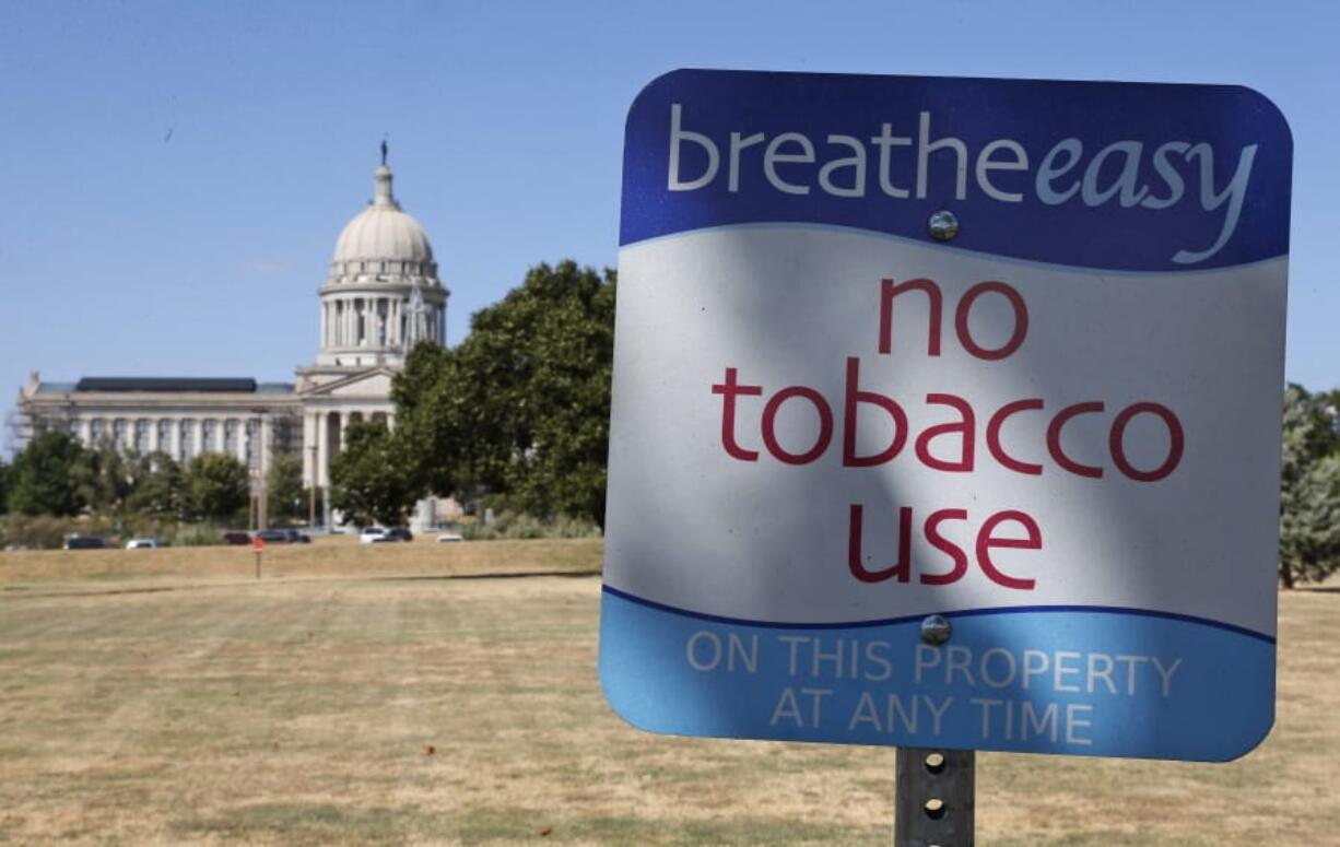 FILE - This Sept. 17, 2015, file photo shows a sign barring smoking at the state Capitol in Oklahoma City. The signs were paid for by the Oklahoma Health Department, which works in conjunction with the Tobacco Settlement Endowment Trust to reduce smoking. Fifteen years after its creation, programs launched by the Tobacco Settlement Endowment Trust have dramatically reduced tobacco use among Oklahomans.