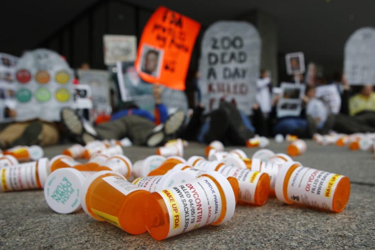 FILE - In this April 5, 2019, file photo, containers depicting OxyContin prescription pill bottles lie on the ground in front of the Department of Health and Human Services’ headquarters in Washington as protesters demonstrate against the FDA’s opioid prescription drug approval practices.