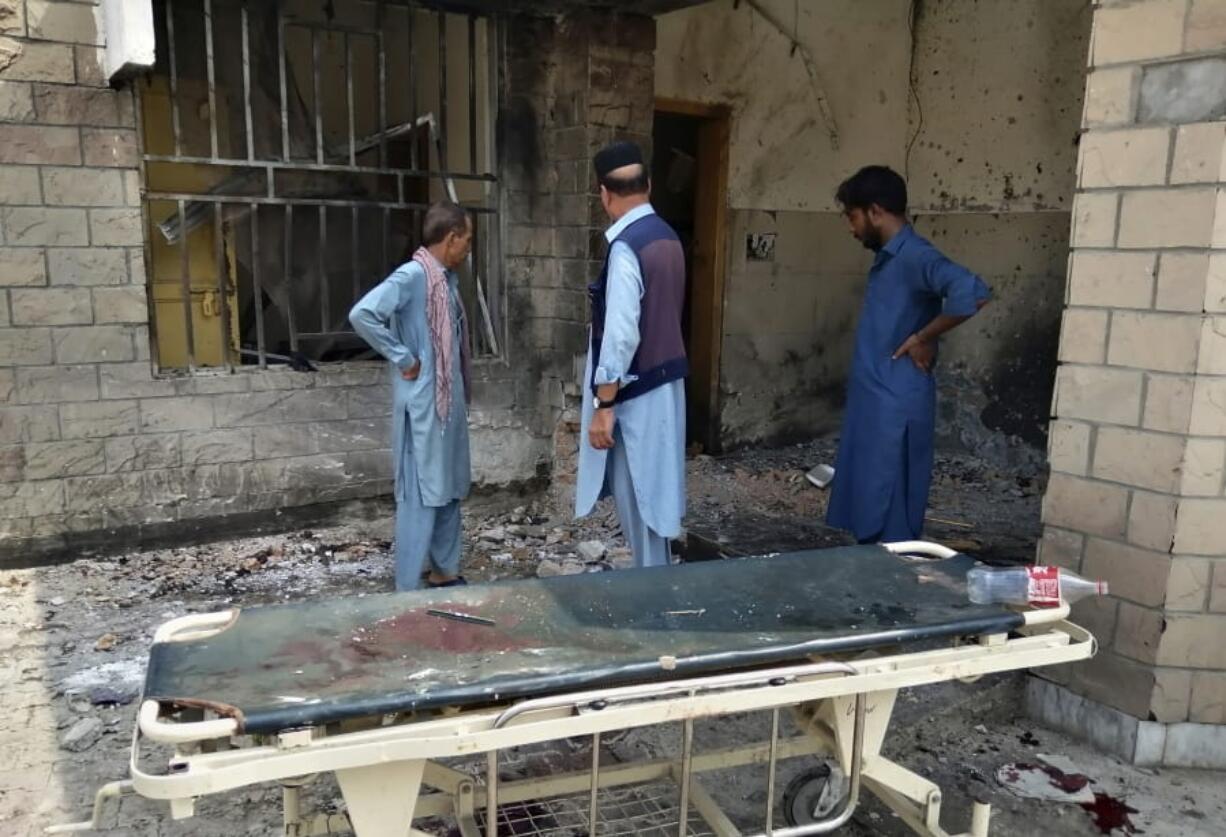 Hospital staff gather at the site of a bombing on an entrance of a hospital in Dera Ismail Khan, Pakistan, Sunday, July 21, 2019. Police in Pakistan say gunmen opened fire on a police post and then bombed the entrance to a hospital as the wounded were being brought in.