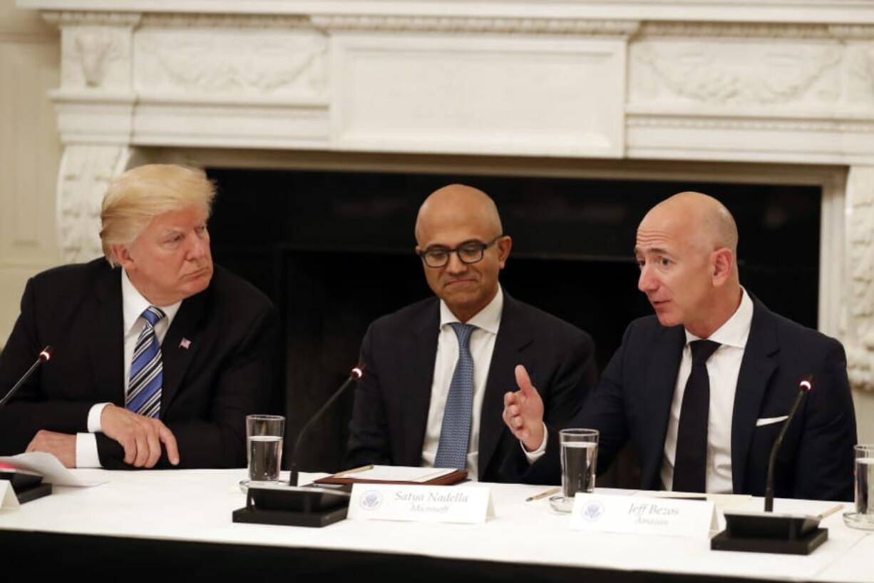 President Donald Trump, left, and Satya Nadella, Chief Executive Officer of Microsoft, center, listen as Jeff Bezos, Chief Executive Officer of Amazon, speaks on June 19, 2017, during an American Technology Council roundtable at the White House in Washington.