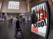 People walk by a poster from the right-wing Swiss People’s Party depicting a woman wearing a burqa in front of a Swiss flag upon which are minarets, which resemble missiles in November 2009 at the central station in Geneva, Switzerland. Later in the month, a successful referendum banned the construction of new minarets in the country.