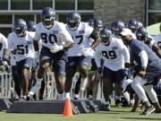 Seahawks defensive tackle Jarran Reed (90) runs a drill with teammates Thursday. Reed learned this week he will be suspended from the first six games of the season by the league. Ted S.