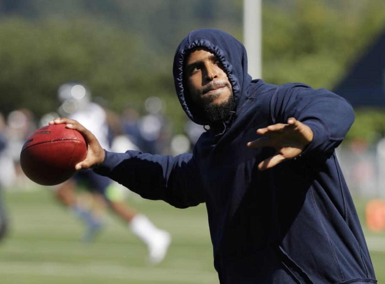 Seattle Seahawks linebacker Bobby Wagner pretends to throw a football to fans during NFL football training camp, Thursday, July 25, 2019, in Renton, Wash. (AP Photo/Ted S.