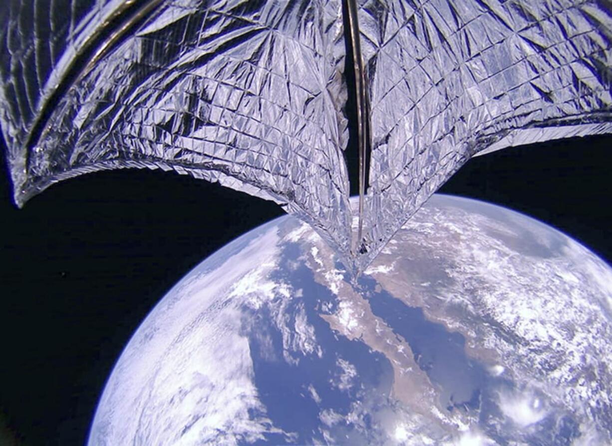 This photo provided on Thursday, July 25, 2019, by the Planetary Society shows a portion of the LightSail2 spacecraft, top, and part of Earth, centered on Baja California, Mexico. It was one of the photos transmitted from The Planetary Society’s LightSail 2 spacecraft, confirming the successful deployment of its solar sail.