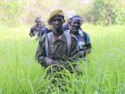 In this photo of Saturday March 16 2019, Rangers walk in a field near the Bire Kpatous game reserve along the Congolese border. South Sudan is trying to rebuild its vast national parks and game reserves following a five-year civil war that killed nearly 400,000 people. The conflict stripped the country of much wildlife but biodiversity remains rich with more than 300 mammal species, including 11 primates, but poaching is a growing threat.