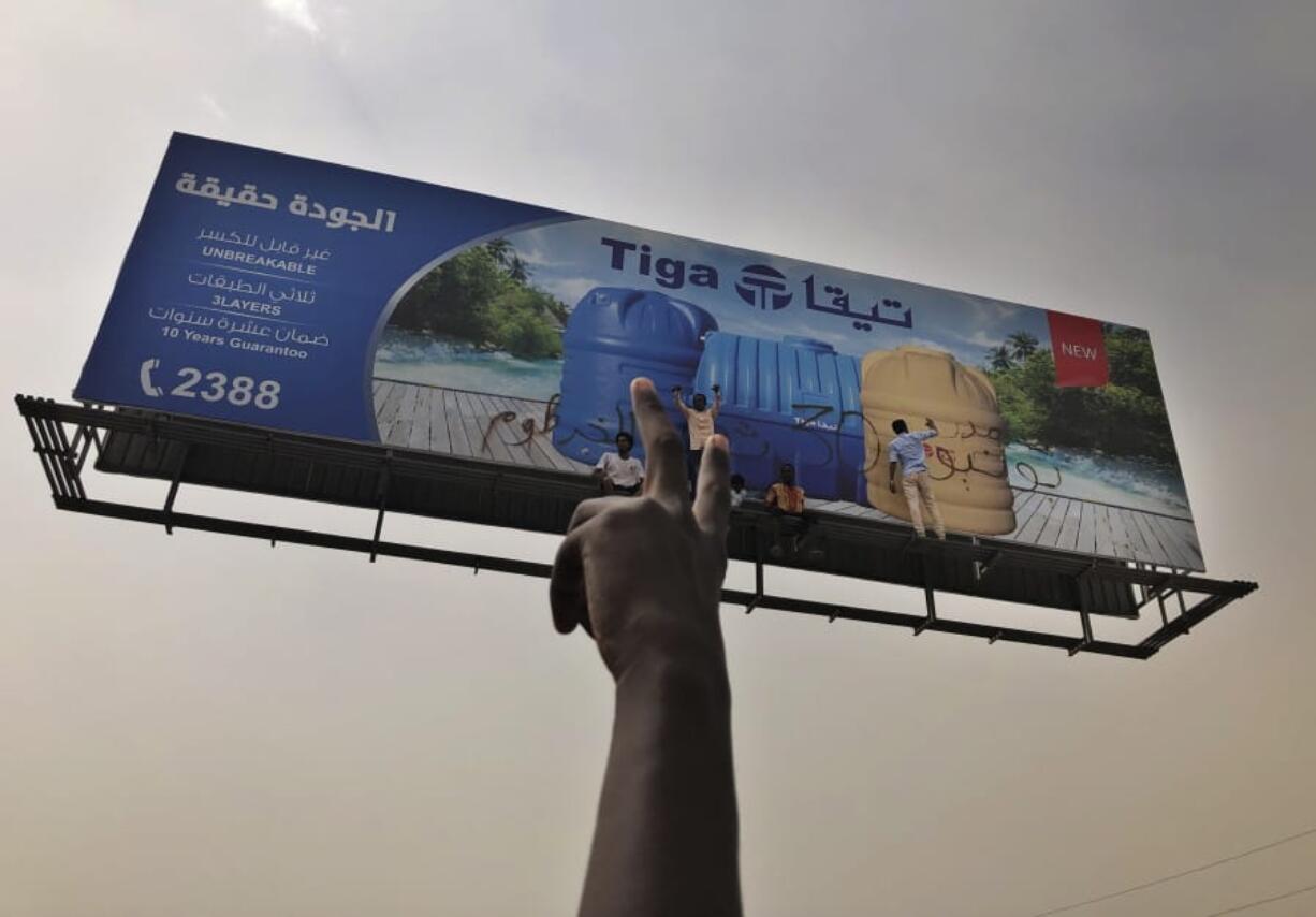 Sudanese protesters write graffiti on a billboard during a demonstration against the military council, in Khartoum, Sudan, Sunday, June 30, 2019. Tens of thousands of protesters have taken to the streets in Sudan’s capital and elsewhere in the country calling for civilian rule nearly three months after the army forced out long-ruling autocrat Omar al-Bashir. The demonstrations came amid a weeks long standoff between the ruling military council and protest leaders.