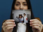 Mary Rose Maher, the daughter of Opus Bono Sacerdotii co-founder Joe Maher, holds a photo from her childhood with her parents in Detroit, Wednesday, June 12, 2019. Opus Bono’s finances came under scrutiny after authorities were contacted by a once-loyal employee - Mary Rose - who began questioning the way money was spent.