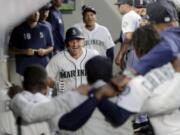 Teammates stand arm-in-arm as they wait to celebrate with Seattle Mariners’ Kyle Seager, center, after Seager hit a solo home run against the Detroit Tigers during the fifth inning of a baseball game, Thursday, July 25, 2019, in Seattle. (AP Photo/Ted S.