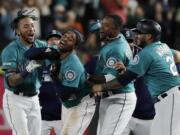 Seattle Mariners' Mallex Smith, second from left, is mobbed by teammates, including J.P. Crawford, left, Tim Beckham, second from right, and Omar Narvaez, right, after Smith hit a walk-off RBI single in the ninth inning of a baseball game against the Detroit Tigers to score Kyle Seager and give the Mariners a 3-2 win, Friday, July 26, 2019, in Seattle. (AP Photo/Ted S.