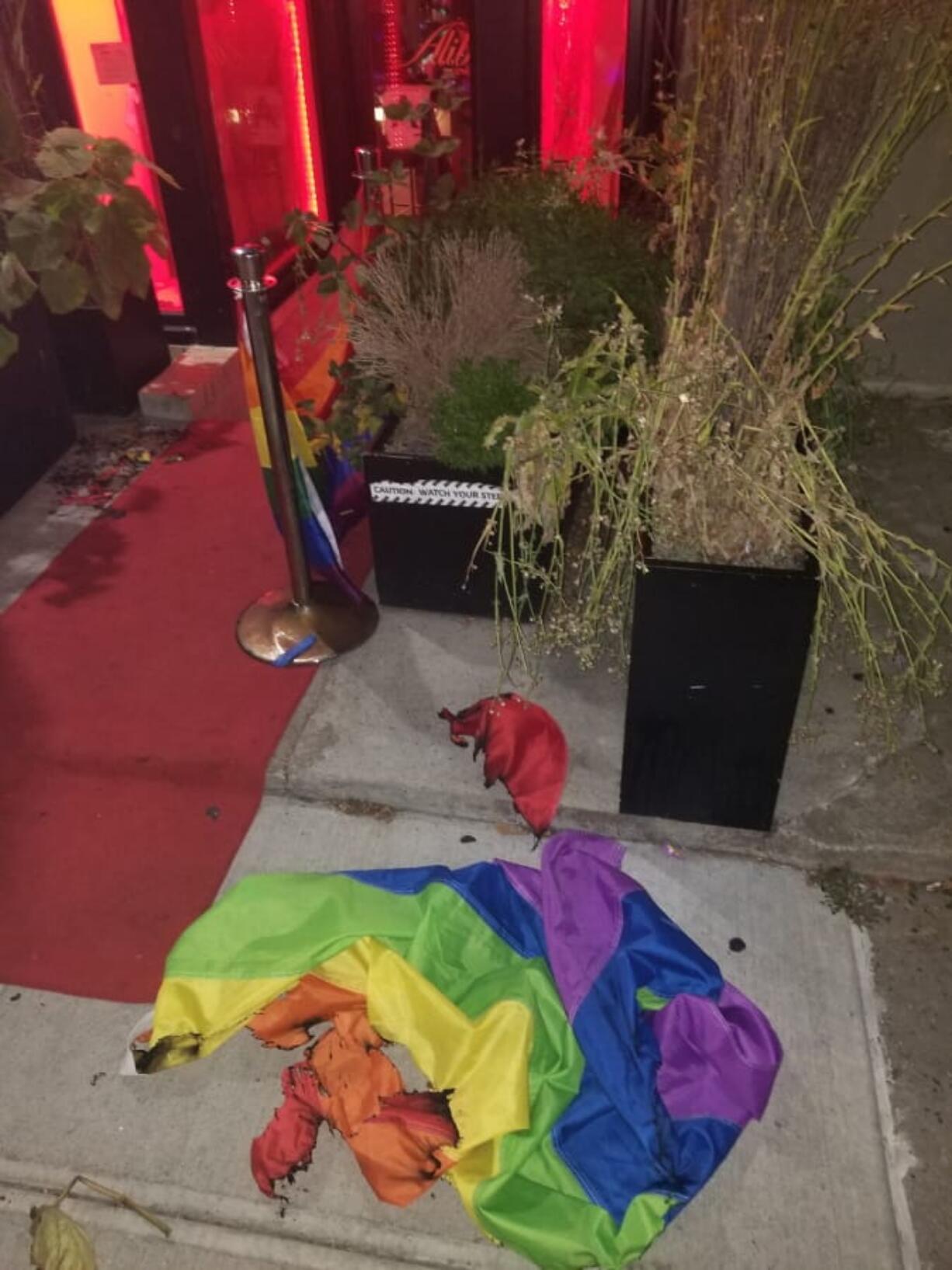 A burned rainbow flag lays on the stoop of the Alibi Lounge, early Monday, July 8, 2019, in New York City, New York. The owner of a New York City gay bar says a rainbow flag was set aflame at the club’s entrance for the second time in just over a month. A New York City police spokesman says the early Monday morning incident at Alibi Lounge is being investigated as a possible hate crime.