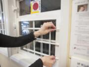 Jan Berichon, a child safety health educator at the Randall Children’s Hospital Safety Center, demonstrates how some of the window safety devices work in 2016. In the summer, window falls become more common, particularly in the Northwest, because many people use open windows to cool their homes.