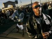 MC Hammer, Chief Strategy Officer for DanceJam.com, poses for a photograph as a dancer performs near Pier 41 in San Francisco, Tuesday, Nov. 20, 2007.   The Web site, scheduled to debut in mid-January, will try to upstage YouTube to become the Internet's hub for sharing and watching dance videos.