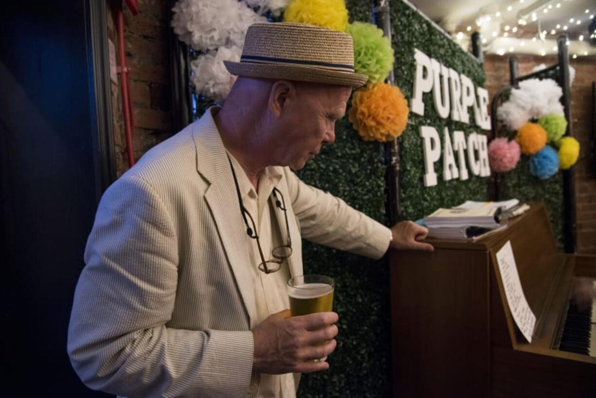 Kevin Lambert, co-organizer of the weekly open-piano nights at Purple Patch restaurant, listens to performances on a recent evening at the establishment.