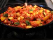 Ratatouille typically consists of roughly equal amounts of eggplant, zucchini and bell pepper, flavored with onion, garlic and herbs. Tomato is added in direct proportion to the cook’s tastes.