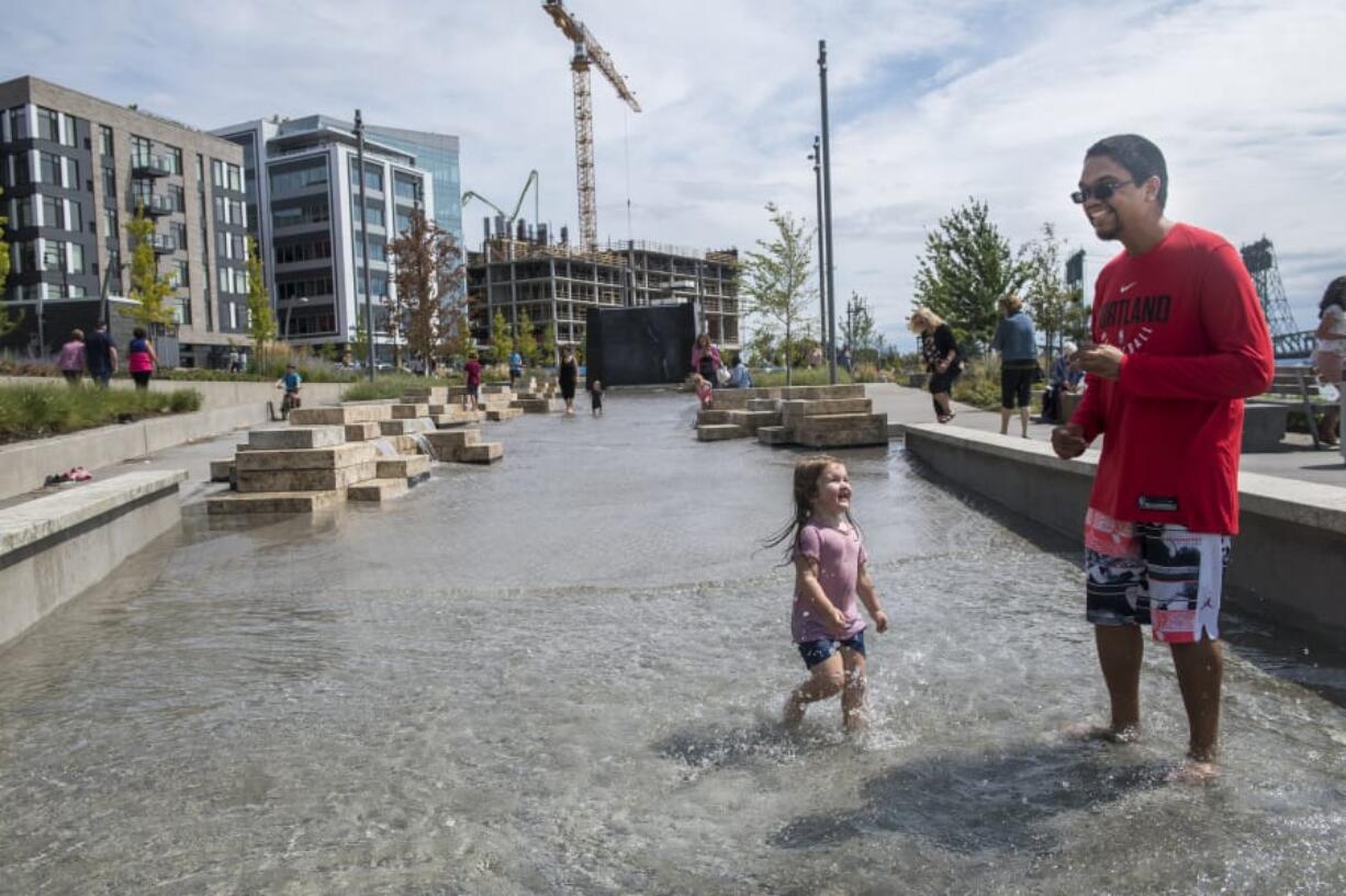 Adaline Sokol, 2, left, and Gage Marshall splash in the new Columbia River water feature on Aug. 9 at The Vancouver Waterfront. Since it opened earlier this month, the water feature has become a popular spot on hot days. Tuesday and Wednesday are forecast to be among the area’s hottest this year.