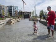 Adaline Sokol, 2, left, and Gage Marshall splash in the new Columbia River water feature on Aug. 9 at The Vancouver Waterfront. Since it opened earlier this month, the water feature has become a popular spot on hot days. Tuesday and Wednesday are forecast to be among the area’s hottest this year.